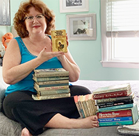 Jen with books, holding an early paperback copy of THE CHEERLEADER